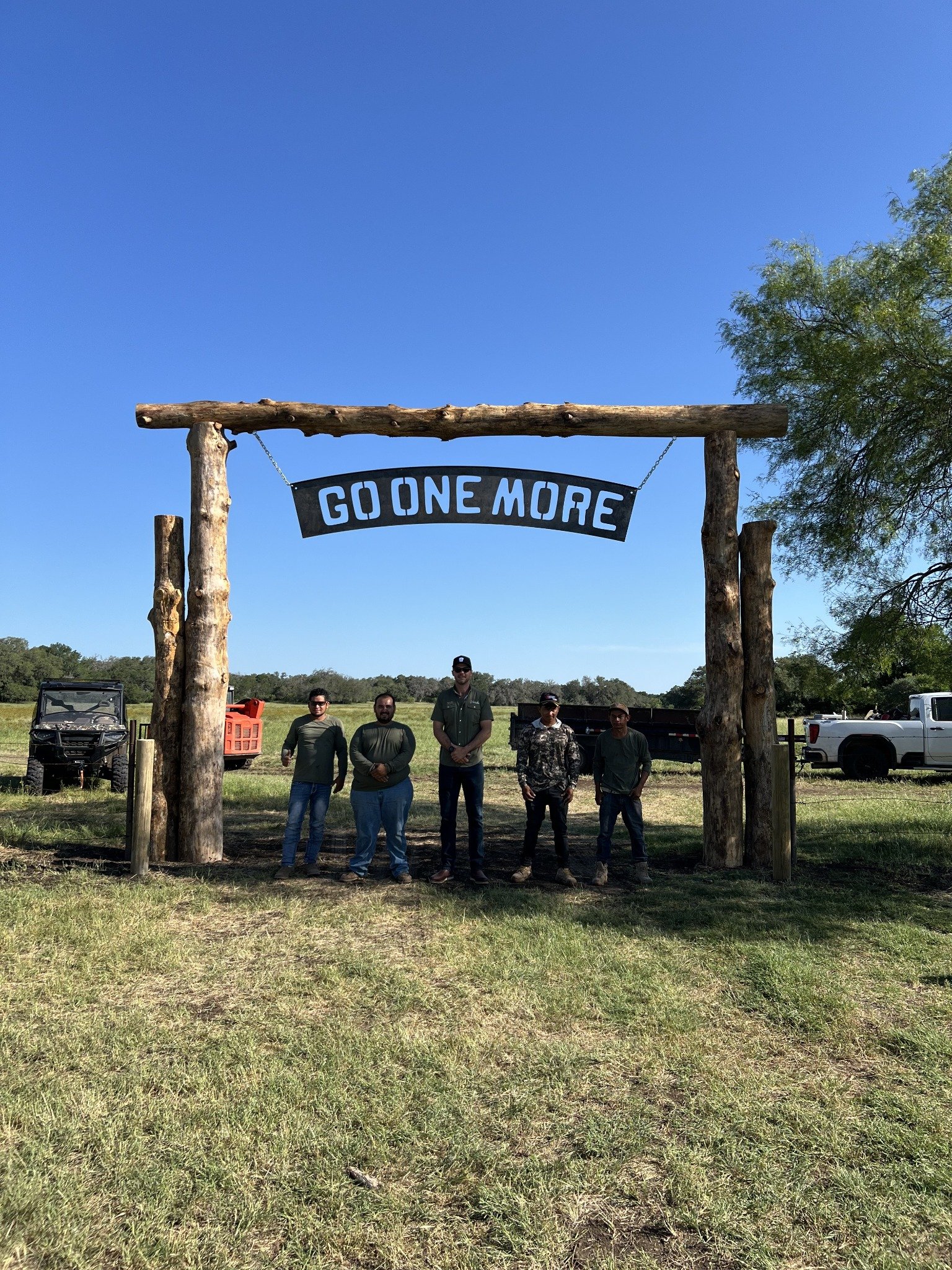 Verde Landscape Services team beneath the Go One More ranch entrance at Bare Ranch