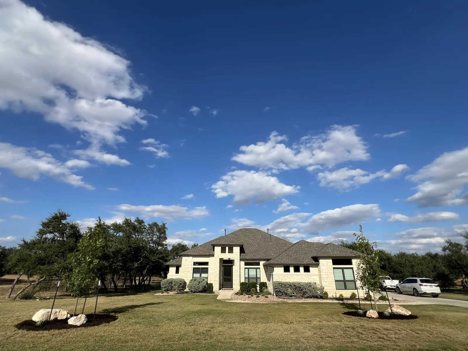 A residential home framed by lawn, trees and landscape beds in Liberty Hill