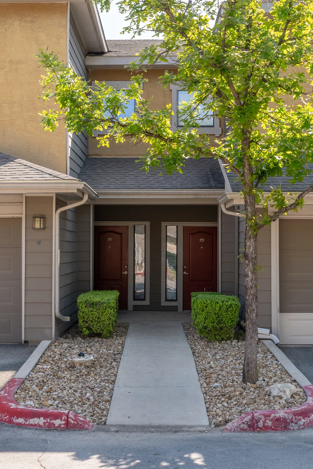Defined rock beds frame a townhome entrance.